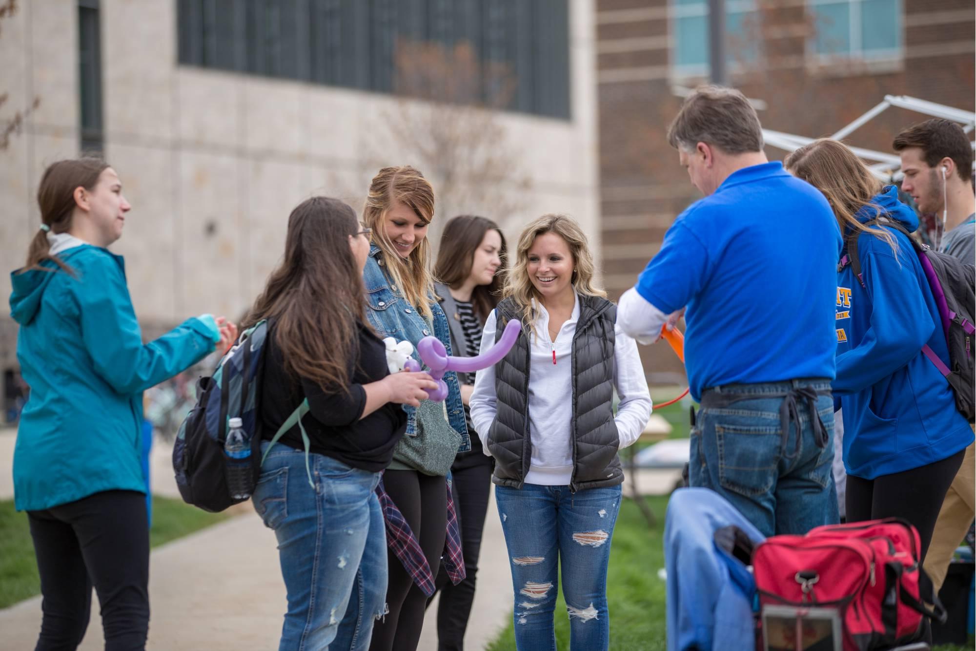 GVSU students receiving balloon animals at ExtravaGRANDza